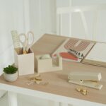 A complete 10-piece KIBAGA desk organizer set in beige and gold, including a stapler, scissors, pen holder, and tape dispense