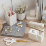 A complete 10-piece KIBAGA desk organizer set in beige and gold, including a stapler, scissors, pen holder, and tape dispense