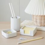 A set of three gray concrete desk organizers, including a pen holder, a notes holder, and a small dish for clips, arranged on