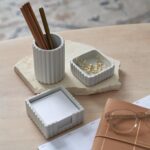 A set of three gray concrete desk organizers, including a pen holder, a notes holder, and a small dish for clips, arranged on