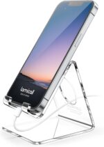 A clear acrylic cell phone stand holding a smartphone on a desk, showcasing its transparent design and cable management.