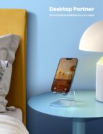 A clear acrylic cell phone stand holding a smartphone on a desk, showcasing its transparent design and cable management.