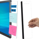 Two clear acrylic MDOZQ monitor memo boards, one on each side of a computer screen, holding yellow sticky notes.
